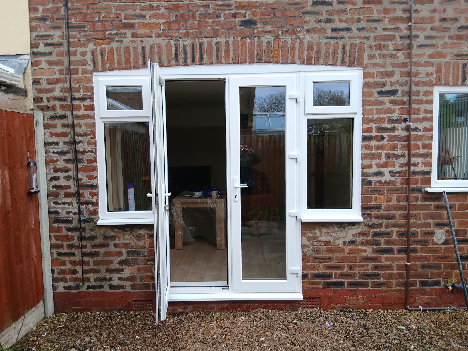 White French doors with side windows fitted into a brick wall