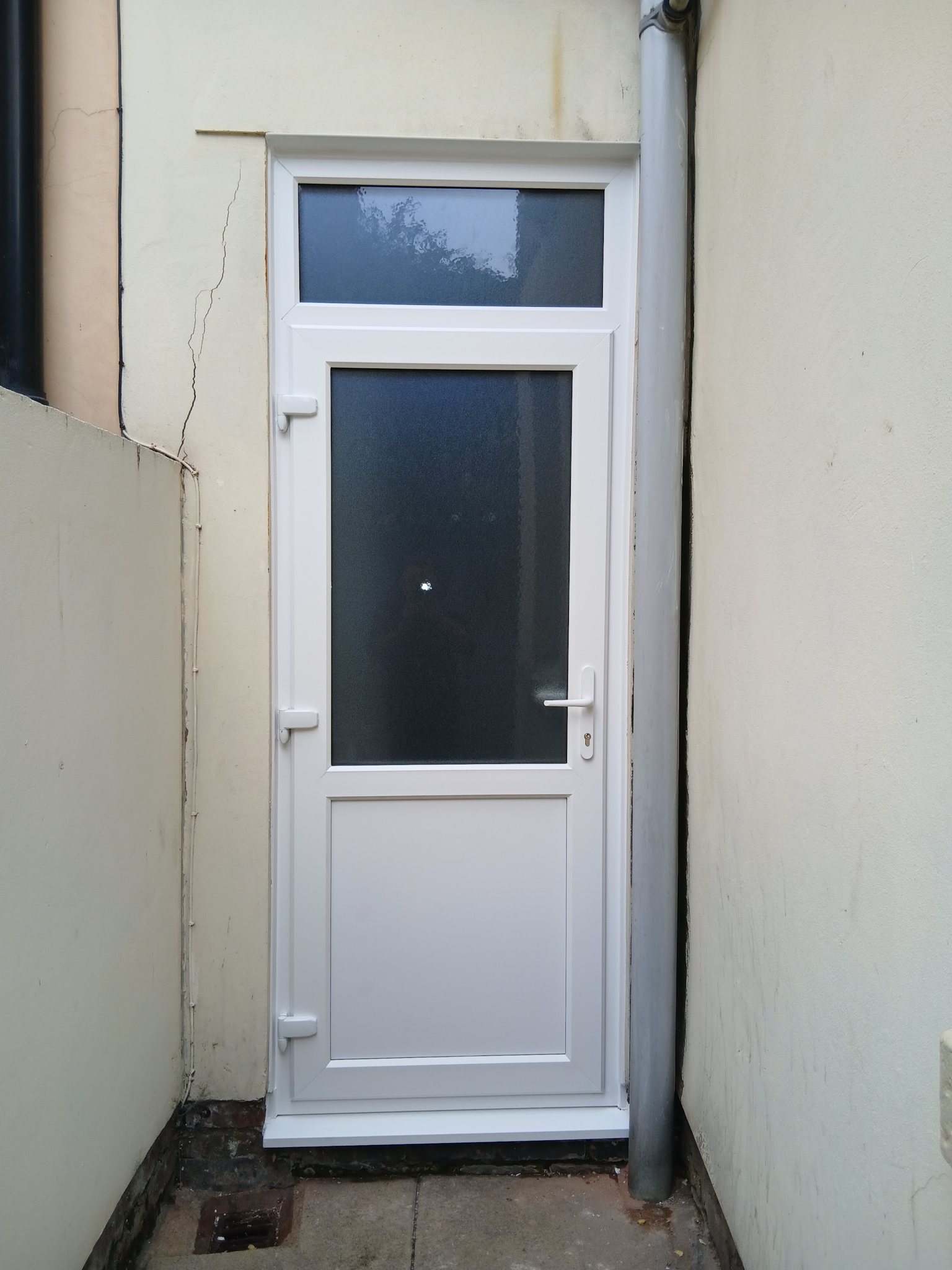 A white back door with obscure glass and a glazed panel above
